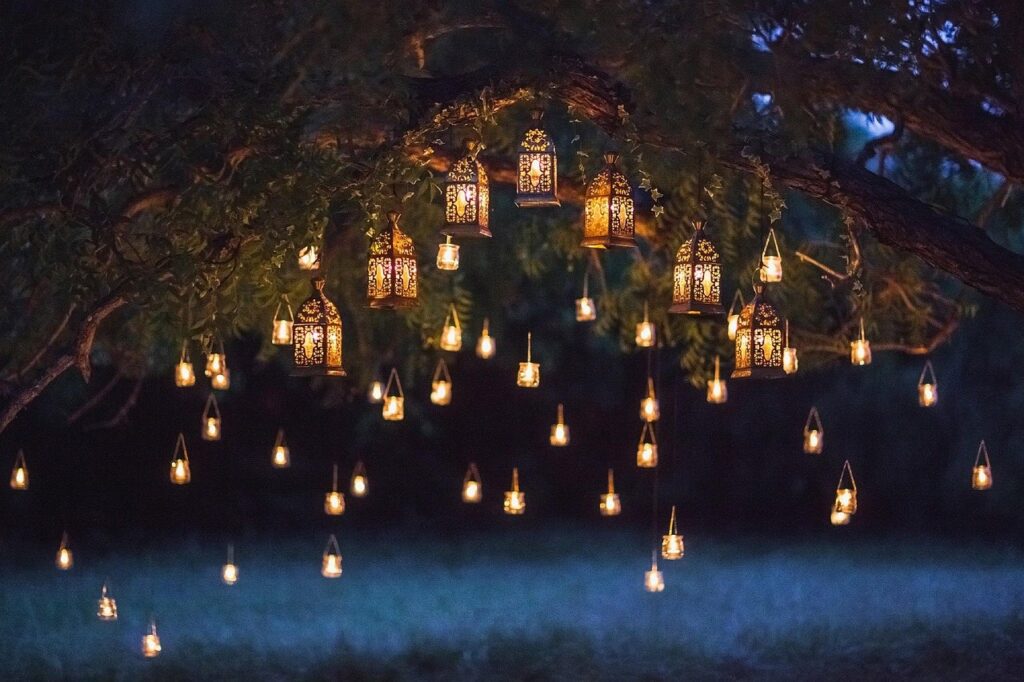Lanterns and warm lights hung in a yard tree