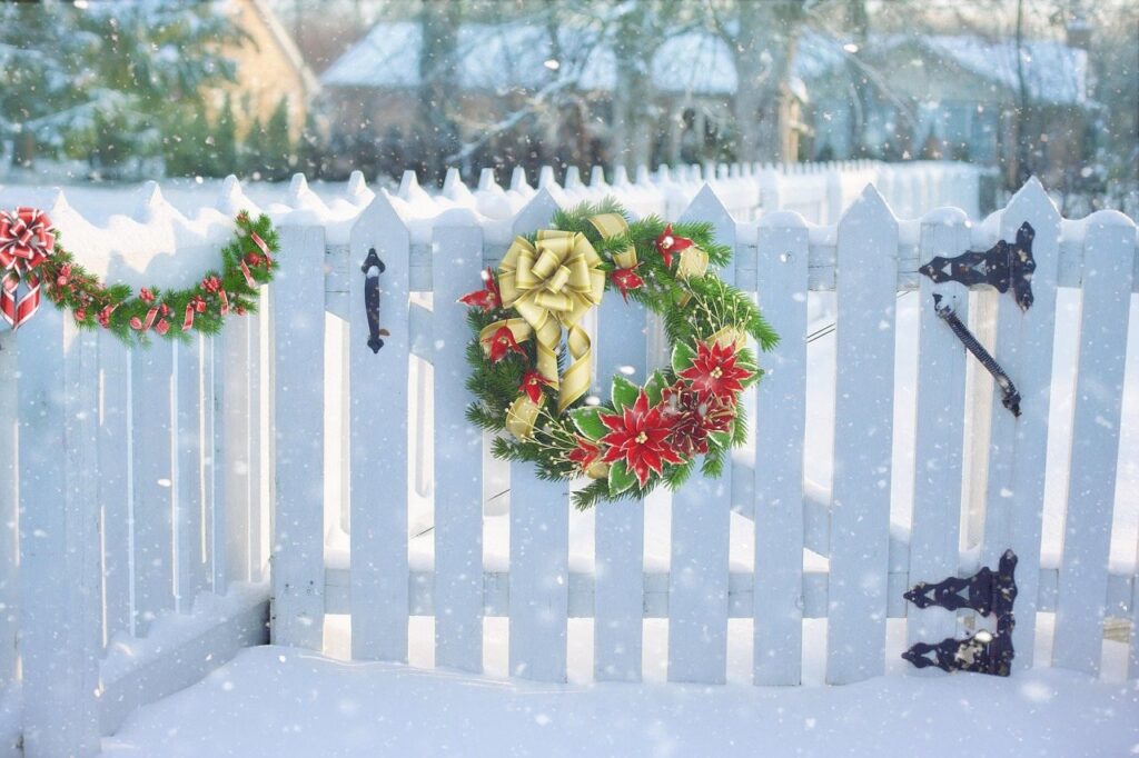 Christmas wreath on a white picket gate