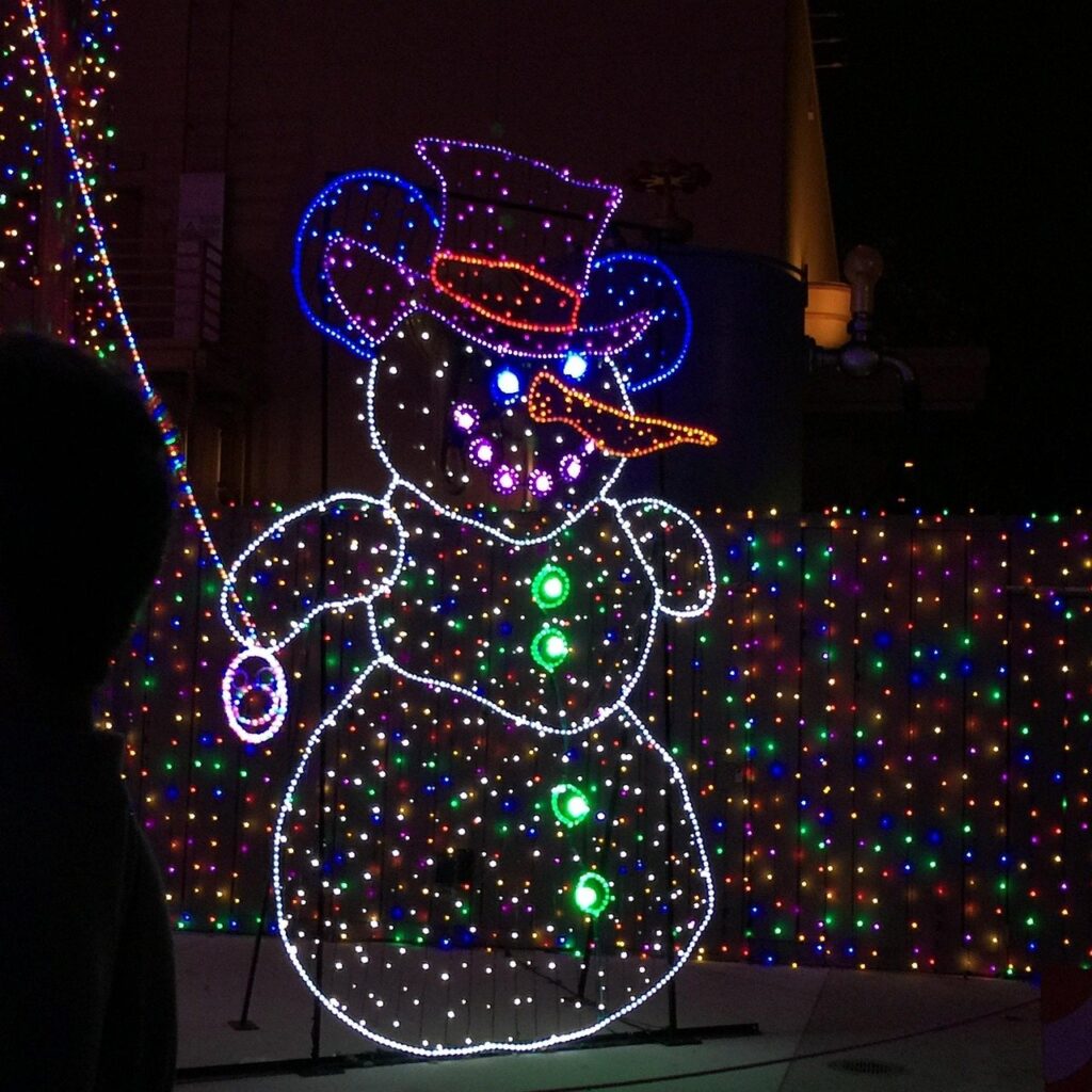 Snowman light display in a yard at night