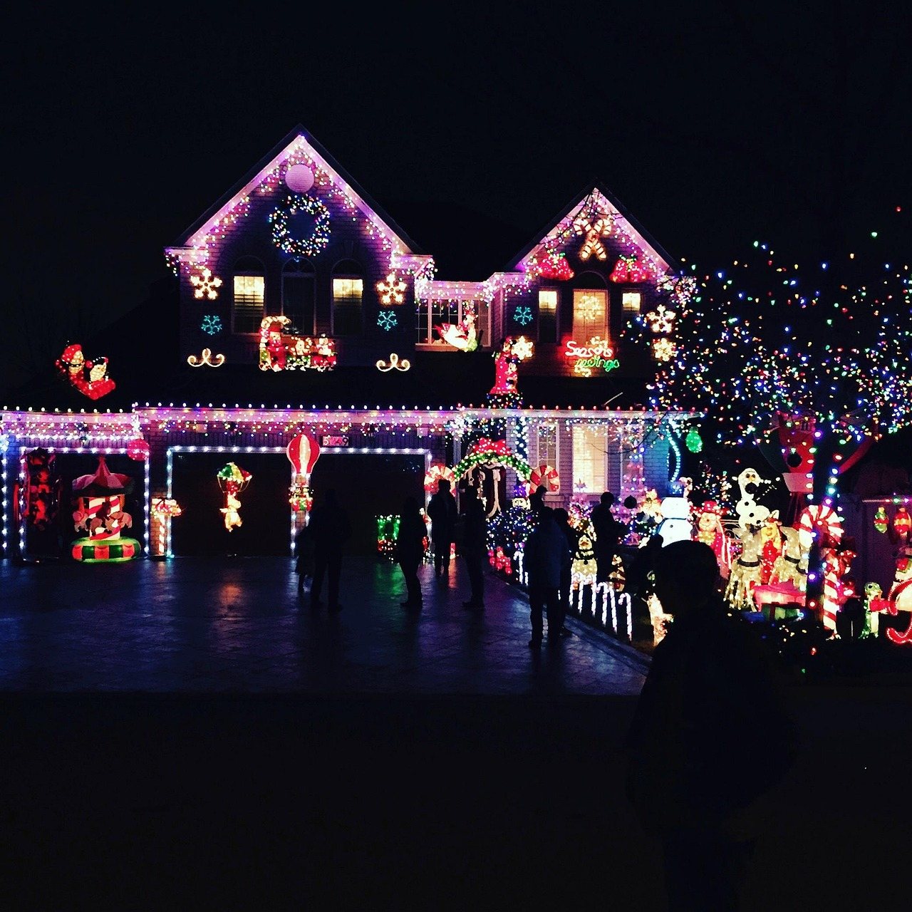 Home covered in Christmas lights with yard displays