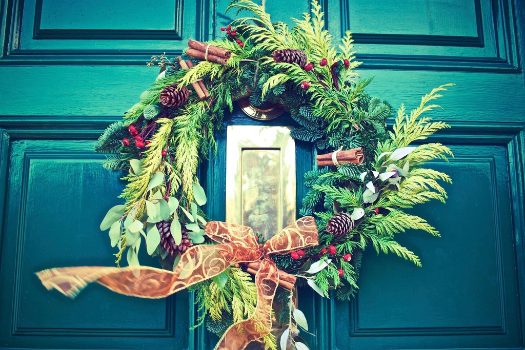 Holiday wreath with a bow on a front door