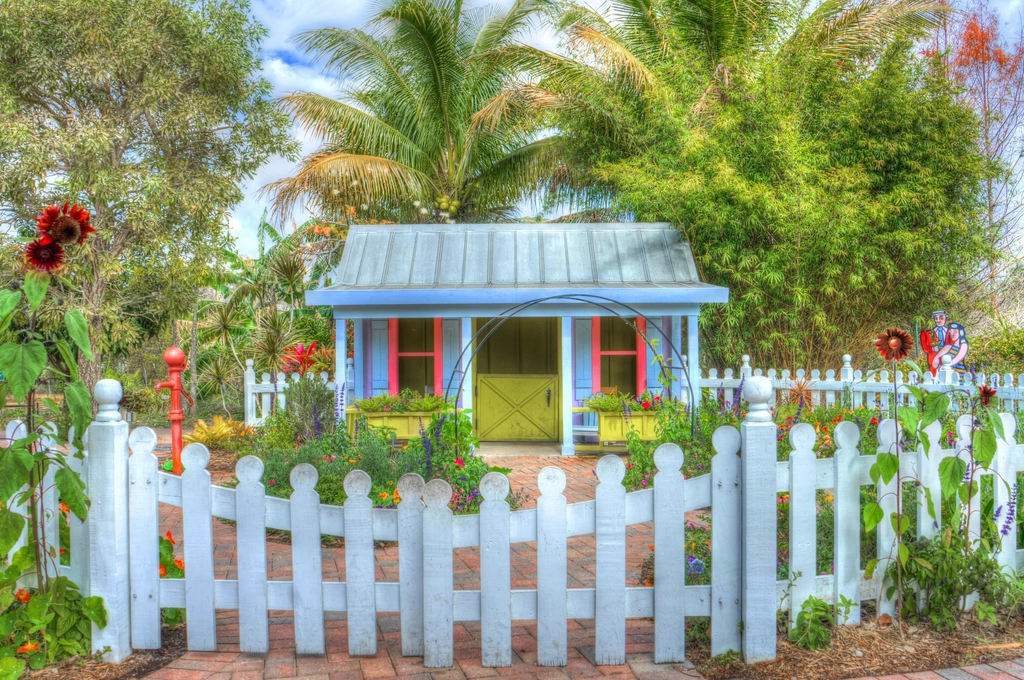 Cottage with a picket fence and palm trees