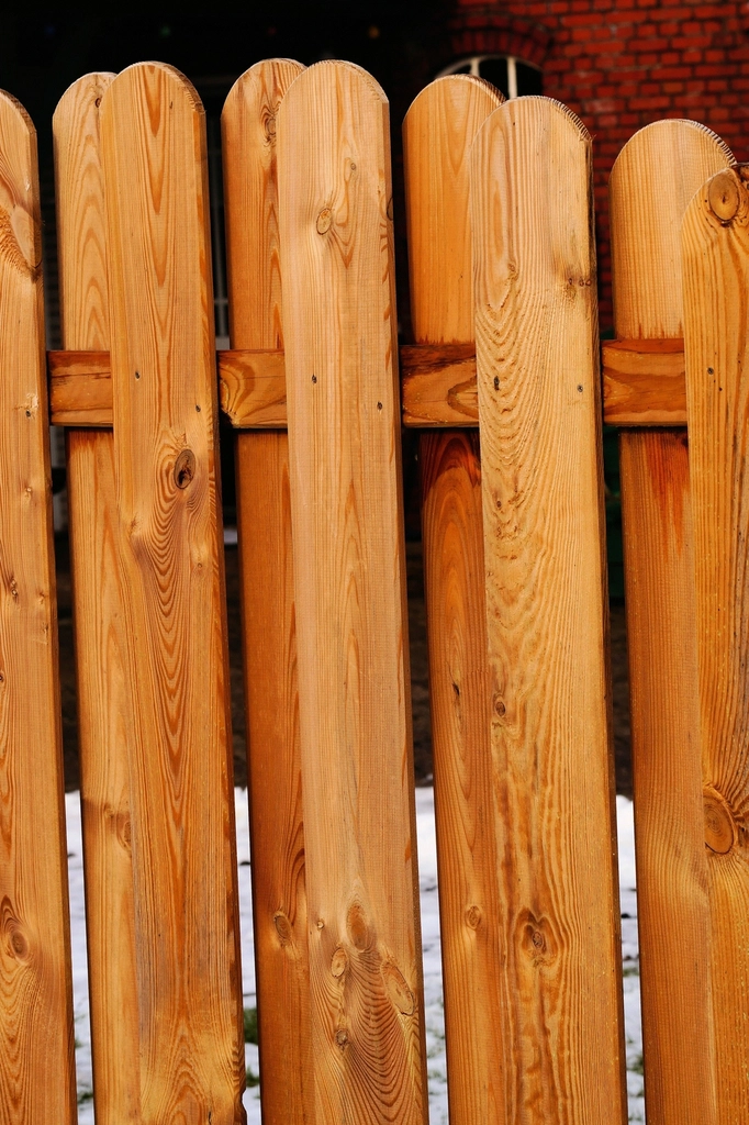 Close-up of new redwood-toned fence boards