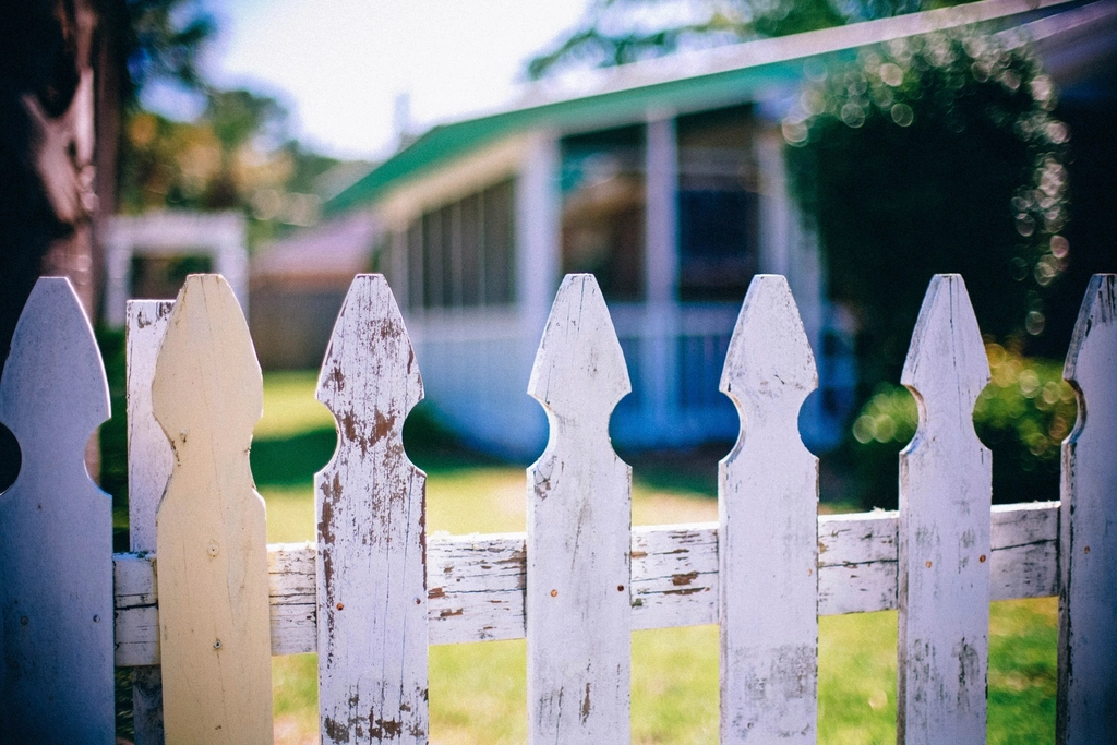 Weathered picket fence in front of a house