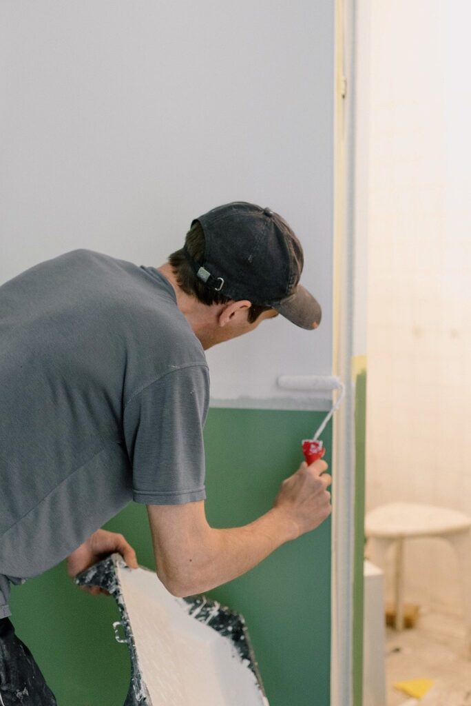 Painter rolling a wall in a room being repainted