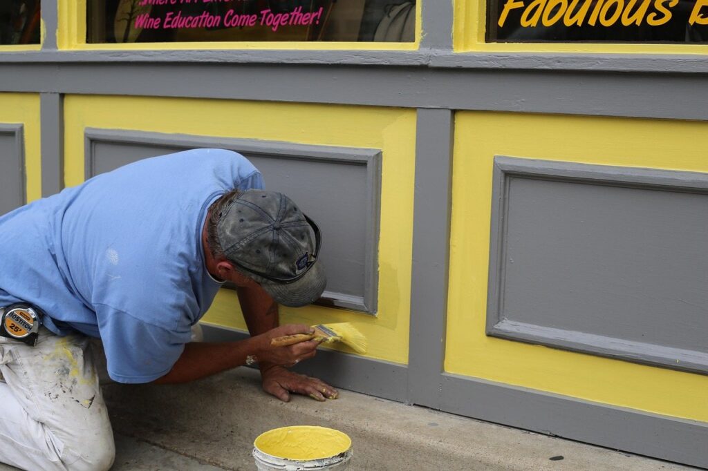 Painter cutting in trim on an exterior wall