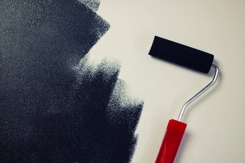 Paint roller finishing a dark accent wall